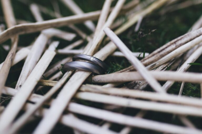 Close-up of elegant wedding rings nestled in bamboo sticks creating a rustic natural backdrop.